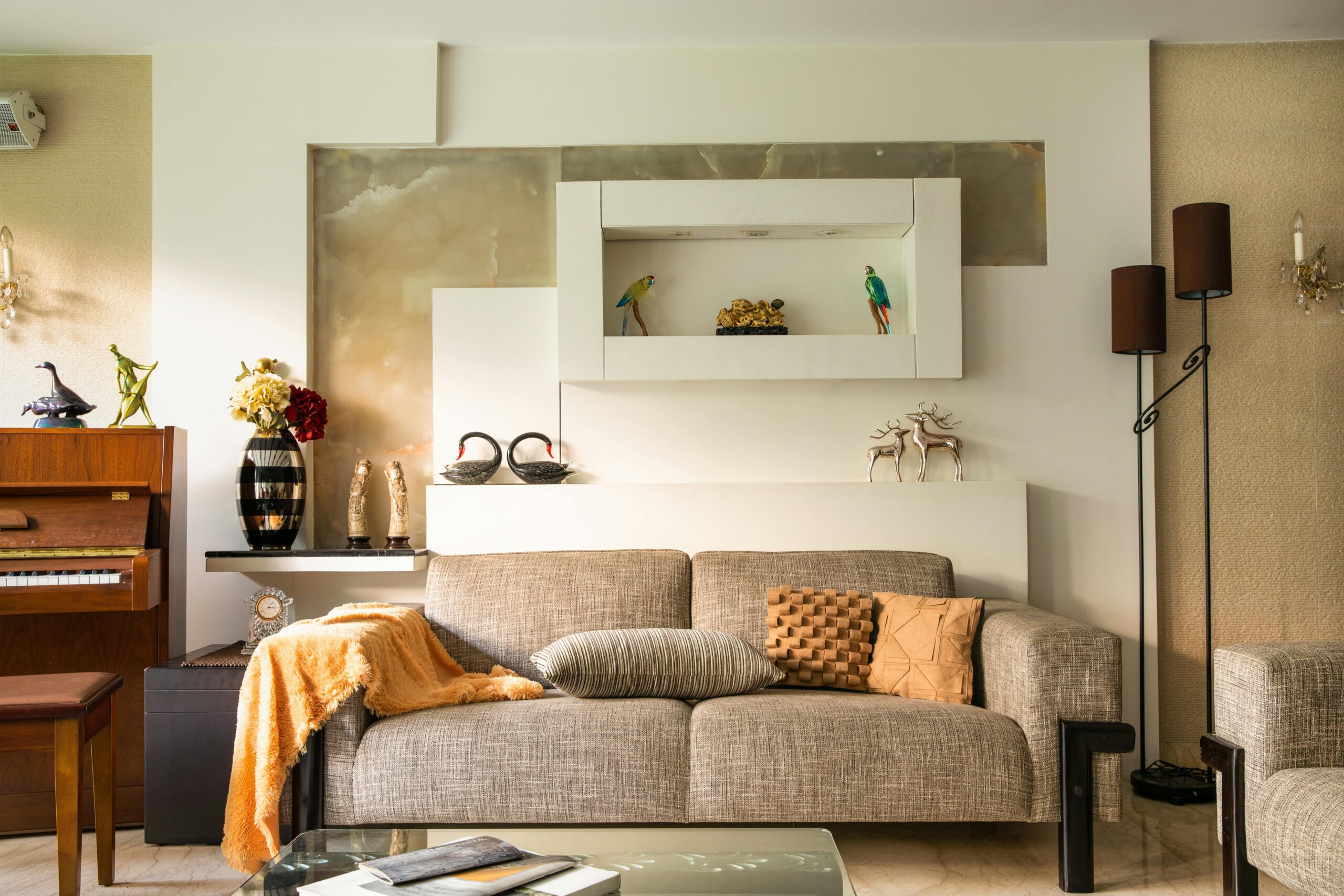 Cozy living room featuring a sofa, decorative items, and a piano, perfect for a stylish home interior.